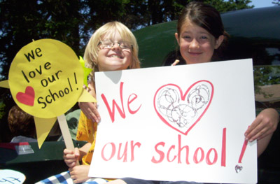 Kids with posters saying "we love our school"